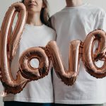 woman in white crew neck shirt with brown and white heart shaped beaded necklace
