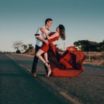 man and woman doing dance post in concrete road at daytime